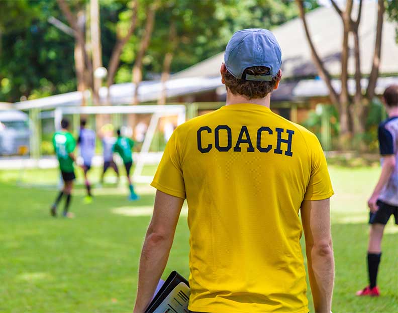 picture of a soccer coach watching the team from the sideline